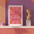 Retro-style poster with psychedelic 1970s-inspired design. Text reads "WEIRD GIRLS DO IT BETTER" in wavy, groovy lettering. Pink and orange sunburst background. Centered text surrounded by curved rays. Bold red frame with scalloped edges. Vibrant colors and playful typography create a vintage hippie vibe. Square format print with rounded corners. Perfect for fans of retro aesthetics and empowering slogans.